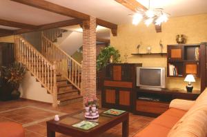Una sala de estar con una escalera y un televisor. en Casa Rural Valle Esgueva, en Burgos