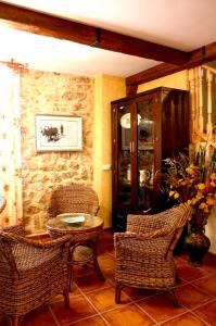 Habitación con sillas de mimbre y mesa con mesa. en Casa Rural Valle Esgueva, en Burgos
