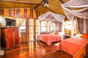 a bedroom with two beds and a television in it at Redwood Beach Resort in Mechapa