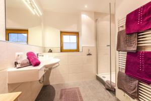 a bathroom with a sink and a shower with purple towels at Haus Viktoria in Längenfeld