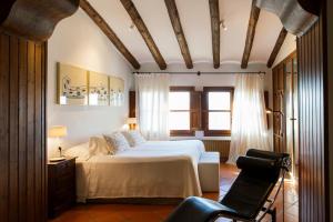 1 dormitorio con 1 cama y 1 silla en Hotel Cresol, en Calaceite