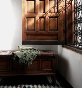 a bench in a room with a wooden door at Dar Seffarine in Fez