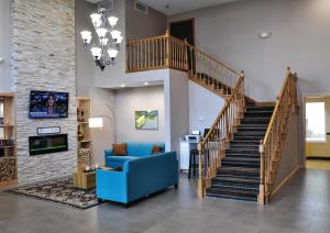 un soggiorno con scala e divano blu di Country Inn & Suites by Radisson, Fairborn South, OH a Fairborn