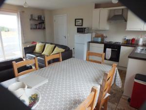 eine Küche und ein Wohnzimmer mit einem Tisch und einem Sofa in der Unterkunft Cluain Uilinn in Miltown Malbay