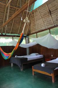 a room with two beds and a hammock at Paradise Amazon Tambopata Ecolodge in Puerto Maldonado