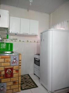a kitchen with a white refrigerator and a stove at Quitinete Cabo Frio , 300 metros da Praia do Forte in Cabo Frio +11 photos