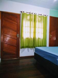 sypialnia z drzwiami i zieloną zasłoną w obiekcie Quitinete Cabo Frio , 300 metros da Praia do Forte w mieście Cabo Frio