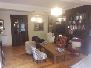 a living room with a table and chairs and bookshelves at Chambres d'hôtes Belle Occitane in Tarascon-sur-Ariège