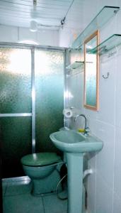 W łazience znajduje się zielona umywalka i toaleta. w obiekcie Quitinete Cabo Frio , 300 metros da Praia do Forte w mieście Cabo Frio