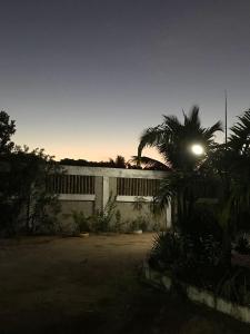 un edificio con una luz de la calle junto a una palmera en Pousadinha Mangabeiras Familia e Grupos en Guriri