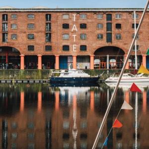 a boat in the water in front of a building at The Liverpool Pod Travel Hostel in Liverpool
