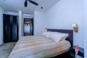 a bedroom with a large bed with a ceiling fan at Makara Rio Suite / Ground Floor in Uvita