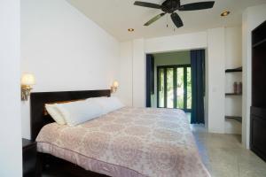 a bedroom with a bed and a ceiling fan at Makara Mono Suite / 2nd Floor in Uvita