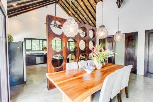 a dining room with a wooden table and white chairs at Makara Suite Penthouse in Uvita
