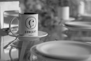 a coffee cup sitting on top of a table with plates at Concept Hotel in Zamora de Hidalgo