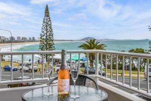 uma garrafa de champanhe sentada numa mesa na varanda em Alex Beach Apt Bilgola4 em Alexandra Headland
