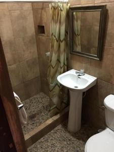 a bathroom with a sink and a shower at Hotel El Reformador in Puerto Barrios