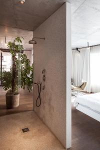 ブリュッセルにあるTeddy Pickerのシャワー付きのベッドルーム1室、角に植物があります。