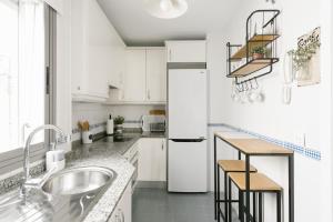 セビリアにあるSevilla Apartments Muroの白いキッチン(シンク、冷蔵庫付)