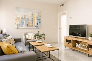 a living room with a couch and a tv at Sevilla Apartments Muro in Seville