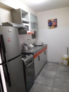 a kitchen with a stove and a refrigerator at Apartamentos Amoblados de 1 Y 2 dormitorios in Lima
