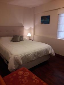 a bedroom with a large bed and a window at Apartamentos Amoblados de 1 Y 2 dormitorios in Lima