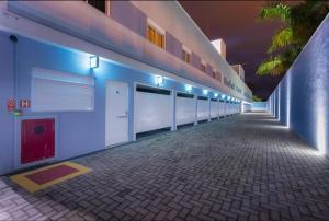 długi korytarz z niebieskimi światłami na budynku w obiekcie Azure Motel (adults only) w mieście Registro