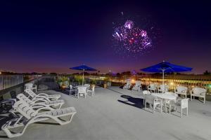 a group of chairs and umbrellas on a patio with fireworks at Anaheim Desert Inn & Suites in Anaheim