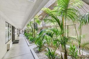 an indoor garden with palm trees in a building at Anaheim Desert Inn & Suites in Anaheim