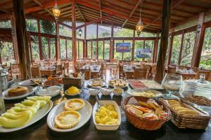 ein Tisch mit vielen Teller Essen drauf in der Unterkunft Lendas do Capão Pousada in Vale do Capao