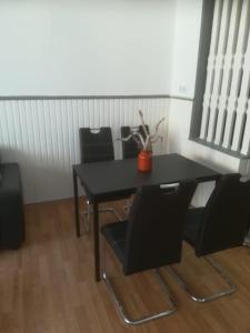 une table et des chaises noires avec une plante sur celle-ci dans l'établissement Zentral gelegene Wohnung in Velbert-Mitte, à Velbert