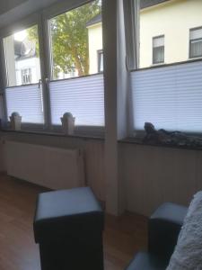 フェルバートにあるZentral gelegene Wohnung in Velbert-Mitteのリビングルーム(窓2つ、スツール2つ付)