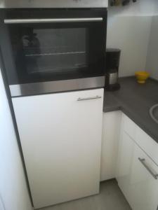 a microwave sitting on top of a white cabinet in a kitchen at Zentral gelegene Wohnung in Velbert-Mitte in Velbert