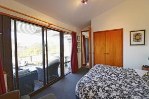 a bedroom with a bed and a view of a balcony at Seavista 2 in Pambula Beach