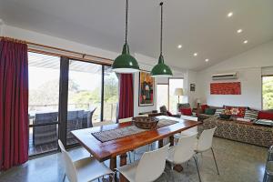 a dining room and living room with a table and chairs at Seavista 2 in Pambula Beach