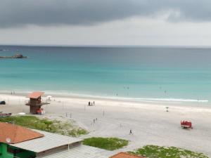 vistas a una playa con gente en el agua en Recanto do Pôr do Sol, en Arraial do Cabo