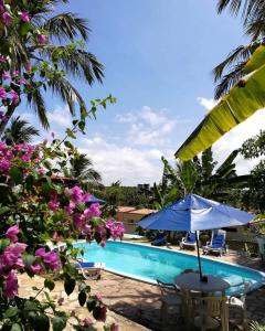 una sombrilla azul junto a una piscina en Hostel do Ceu, en Pipa