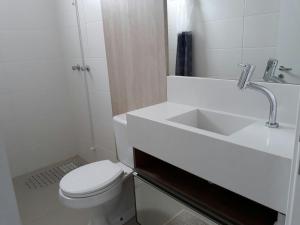 a white bathroom with a sink and a toilet at Sonatta in Torres +18 photos