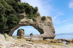 une arche dans une formation rocheuse sur la plage dans l'établissement Spr Guesthouse, à Shirahama