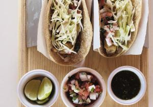 a table with two hot dogs and two bowls of salsa at Stella del Mar in San Felipe