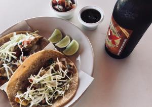 a table with a plate of tacos and a bottle of beer at Stella del Mar in San Felipe