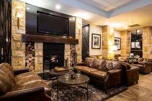 a living room with leather couches and a fireplace at Grand Mercure the Vintage, Accor Vacation Club Apartments in Rothbury