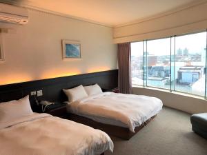 a hotel room with two beds and a large window at 奇萊大飯店 Chuline Hotel in Hualien City