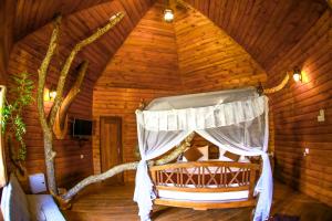 una camera da letto in una baita di tronchi con finestra di La Pentera a Hambegamuwa