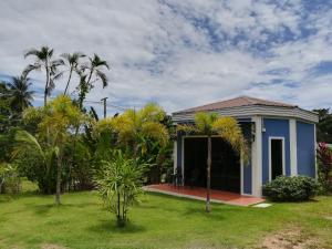 una casa con palmeras en el patio en Green Tree Cottage, en Klong Muang Beach