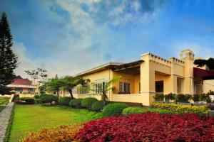 a house with a garden in front of it at Hotel Indah Palace Tawangmangu in Tawangmangu