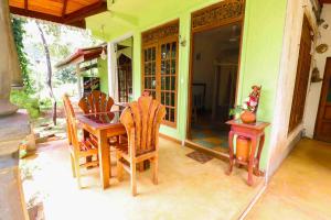 a dining room table and chairs on a patio at Sudumal Cottage in Ella