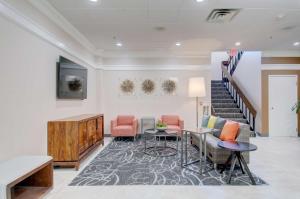 a lobby with a staircase and a table and chairs at Best Western Plus Waltham Boston in Waltham