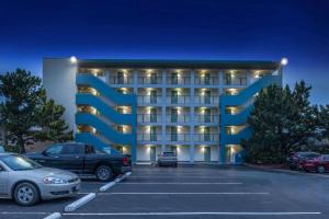 a building with cars parked in a parking lot at Best Western Plus Holiday Sands Inn & Suites in Norfolk