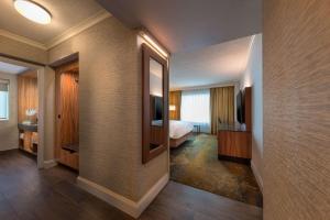 a hotel room with a bed and a mirror at Hyatt Regency Calgary in Calgary